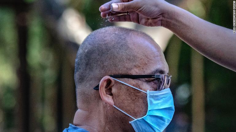 フィリピン・パラニャケでマスク姿のカトリック信者が「灰の水曜日」の礼拝で灰をまかれる＝２月２６日/Ezra Acayan/Getty Images