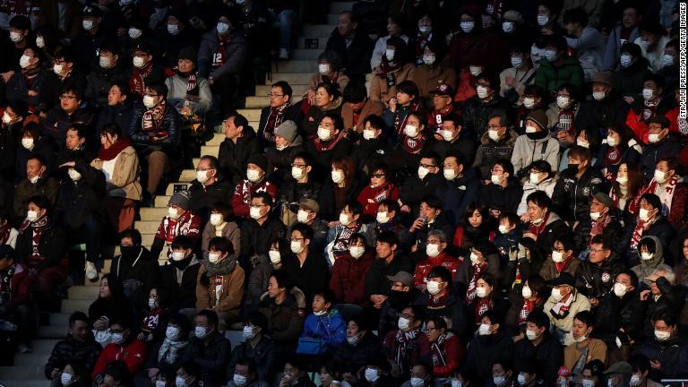 神戸でサッカーの試合を観戦する人々はマスク姿。ヴィッセル神戸は感染拡大防止のために、歌を歌ったり、旗を振ったりしないように求めた。リーグ開幕戦、横浜ＦＣとの試合＝２月２３日/STR/Jiji Press/AFP/Getty Images