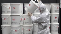 コロナウイルス感染の患者に使われた医療用廃棄物のプラスチック製のバケツを積み上げる人＝２月２４日、韓国・大邱