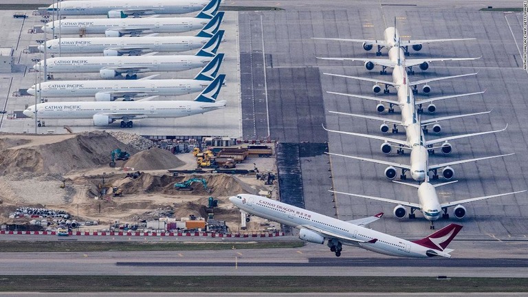 キャセイドラゴン航空機が離陸する背後には駐機するキャセイパシフィックの機体が並ぶ＝３月１０日、香港国際空港/Anthony Wallace/AFP/Getty Images
