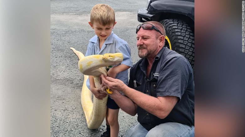 ヘビと写真に収まる捕獲業者のトニー・ハリソンさんと息子のジェンセン君/Gold Coast and Brisbane Snake Catcher
