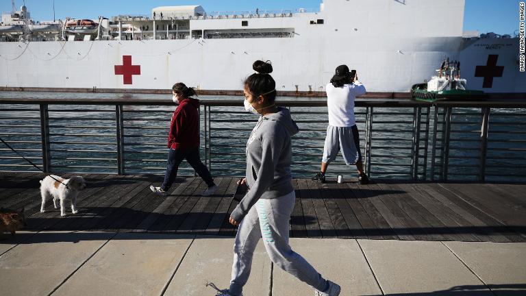 病院船「マーシー」の近くをマスクをして歩く人＝２７日、カリフォルニア州/Mario Tama/Getty Images