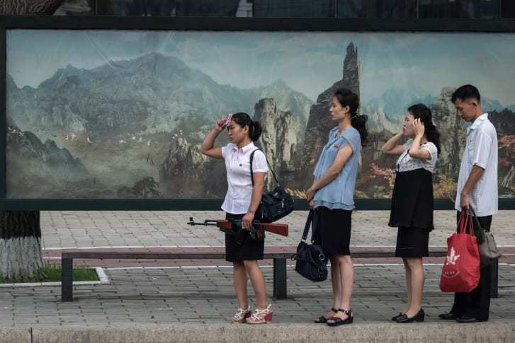 平壌の街路でバスを待つ人々/Ed Jones/AFP/Getty Images