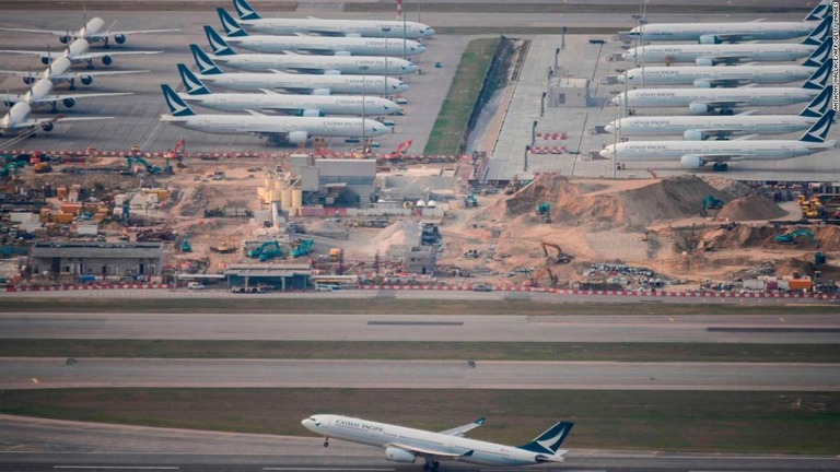 離陸するキャセイパシフィック航空の機体の背景には駐機中の多数の機体が見える＝３月１０日、香港国際空港/Anthony Wallace/AFP/Getty Images