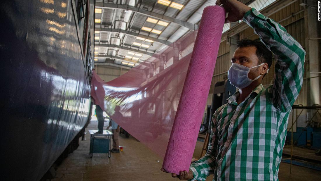 車両の改修で蚊帳をはる作業員/Anupam Nath/AP
