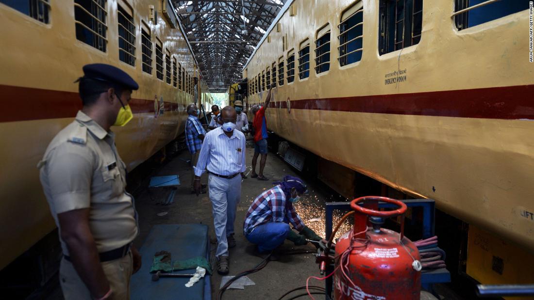 車両工場で作業にあたる人々/Arun Sankar/AFP/Getty Images