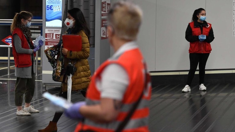 駅でマスクを配るスペイン赤十字のボランティア＝１３日、マドリード/PIERRE-PHILIPPE MARCOU/AFP/Getty Images