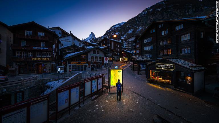 地図を眺める通行人＝スイス/Valentin Flauraud/AFP/Getty Images