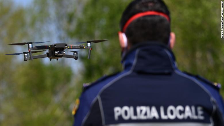 体温センサーを搭載したドローンを操るイタリアの警察官/Miguel Medina/AFP/Getty Images