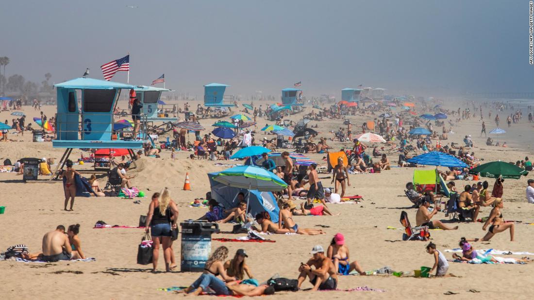 ハンティントンビーチを満喫する人々＝２５日、カリフォルニア州/Apu Gomes/AFP via Getty Images