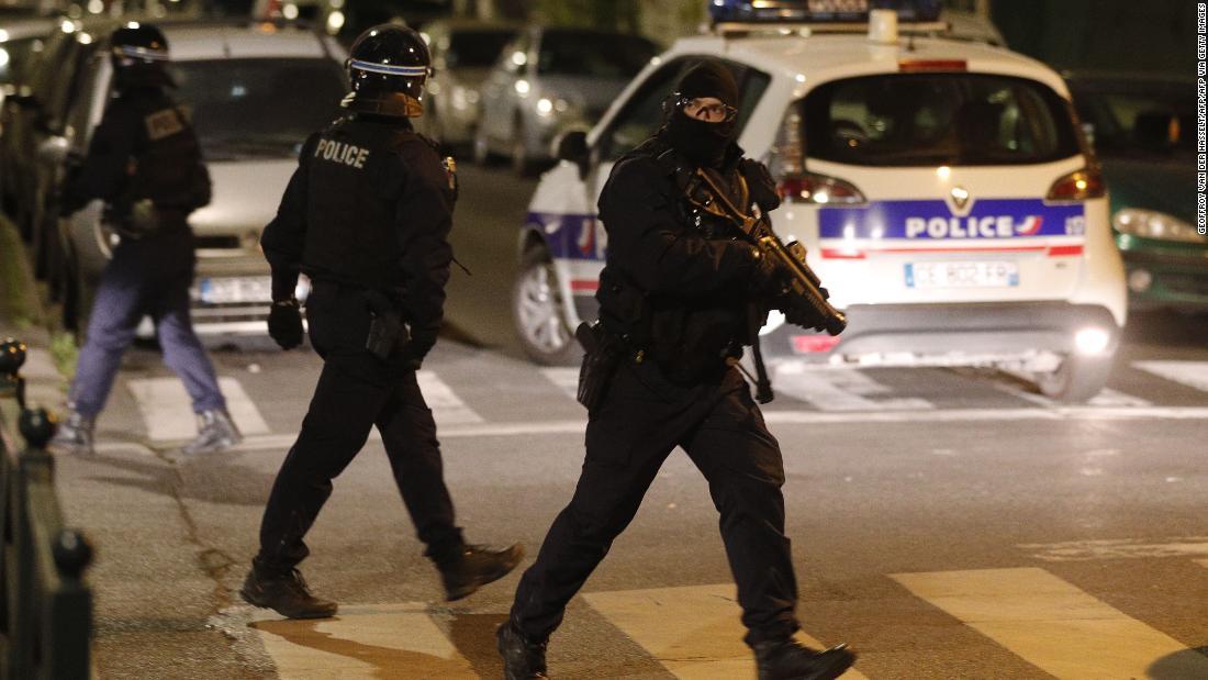 ゴム弾の発射装置を手に道路を歩く警官/GEOFFROY VAN DER HASSELT/AFP/AFP via Getty Images