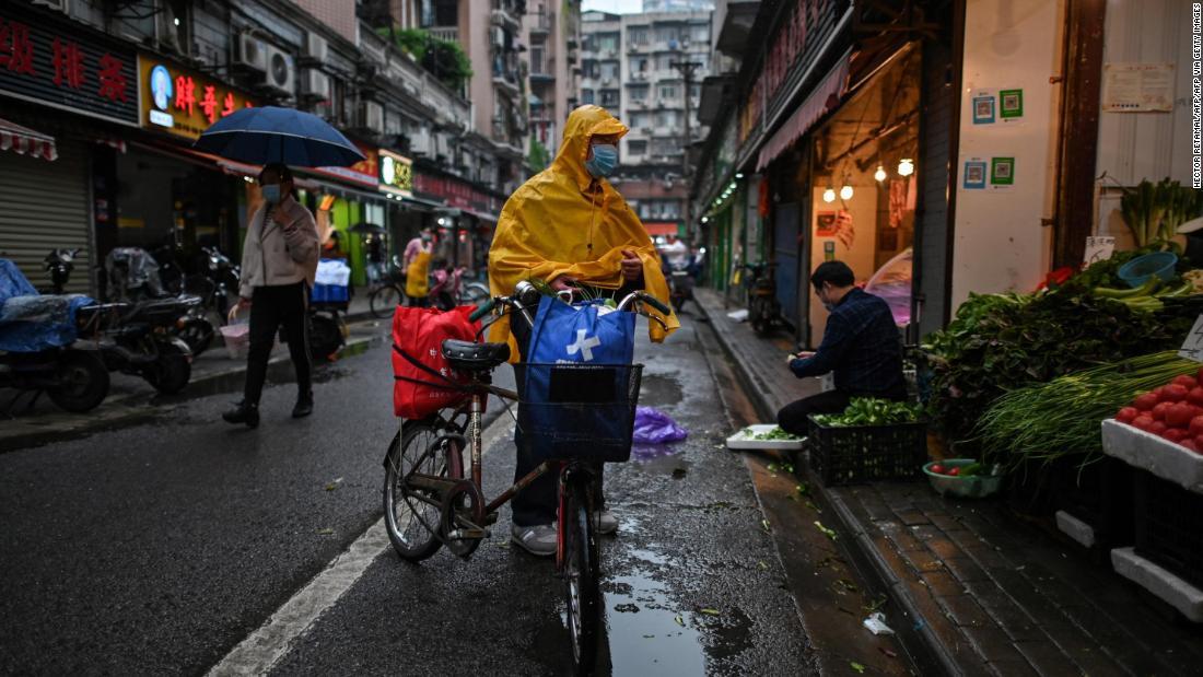 マスクを着用して八百屋を訪れる男性＝１８日、武漢市/HECTOR RETAMAL/AFP/AFP via Getty Images