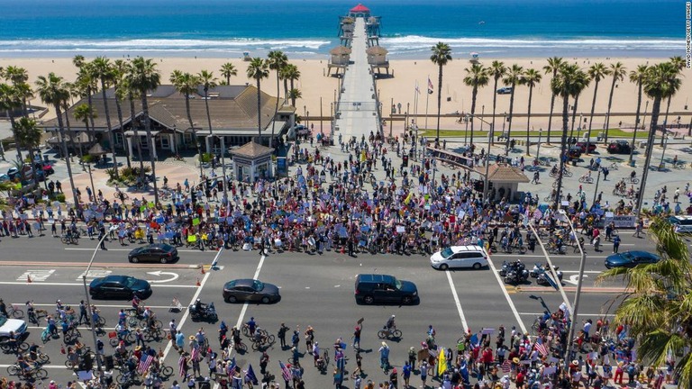 米カリフォルニア州で経済再開を求める抗議集会に参加する人々/David McNew/Getty Images