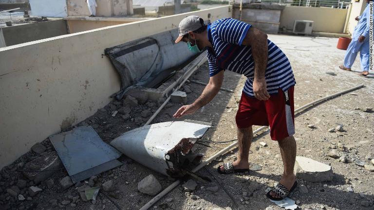 機体の残骸を見つめる男性/Rizwan Tabassum/AFP/Getty Images
