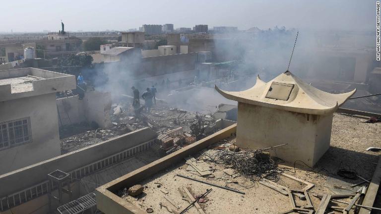 墜落現場の住宅街から煙が立ち上る/Asif Hassan/AFP/Getty Images