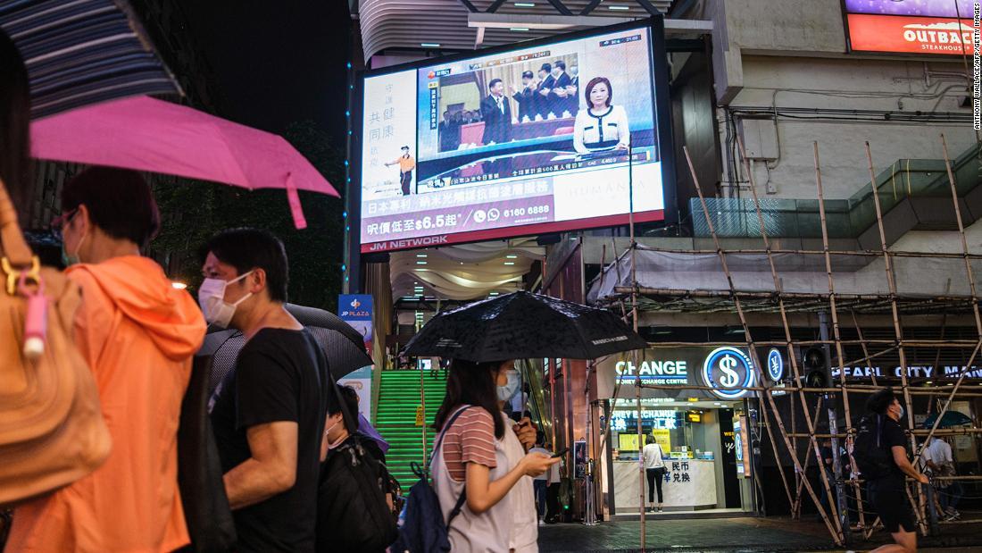 歩行者が全国人民代表大会の様子を伝えるスクリーンの下を歩く様子＝２１日/Anthony Wallace/AFP/Getty Images