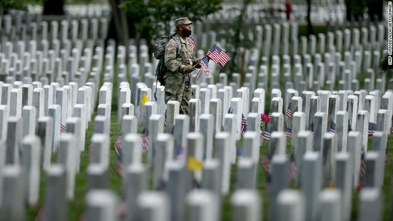 墓の前に旗を立てる兵士/Chip Somodevilla/Getty Images