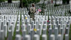 墓の前に旗を立てる兵士