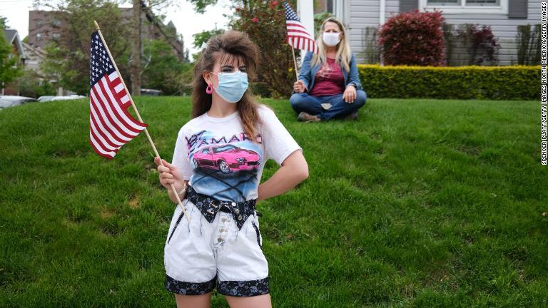 マスクを着けてメモリアルデーのパレードに参加する人々＝２５日、ニューヨーク・スタテン島/Spencer Platt/Getty Images