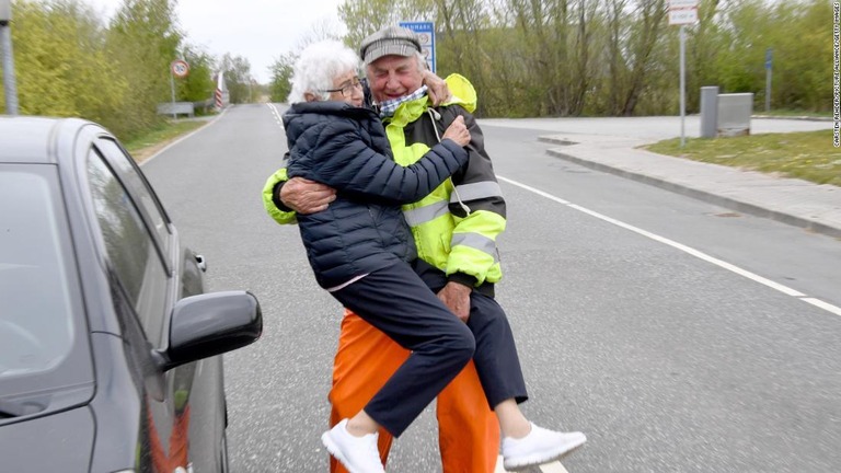 国境でドイツ出身の男性に抱き上げられるデンマーク出身の女性/Carsten Rehder/Picture Alliance/Getty Images