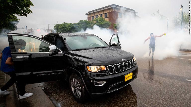 車両の近くで催涙ガスの煙が立ち上る/Carlos Gonzalez/Star Tribune/AP