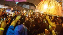 雨の中、フロイドさんが拘束された場所付近に集まるデモ参加者ら