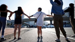 ロサンゼルスの路上で手をつなぐ抗議デモ参加者ら