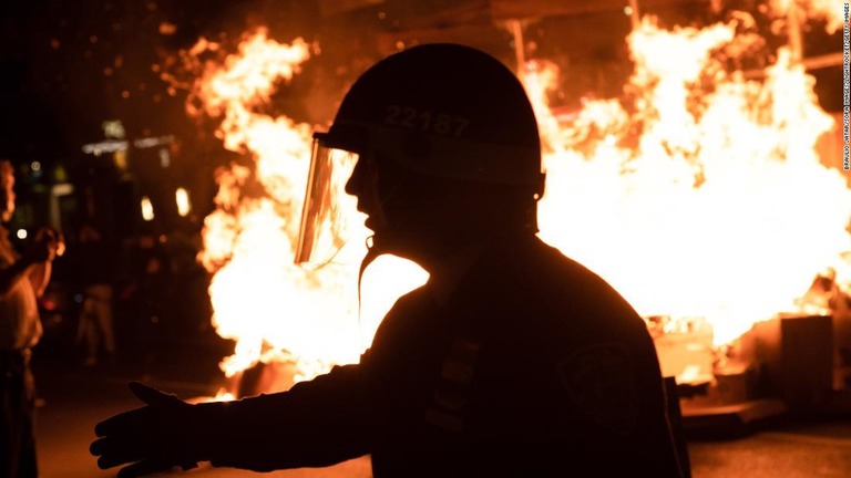 炎からデモ参加者を遠ざけようとする警官/Braulio Jatar/SOPA Images/LightRocket/Getty Images