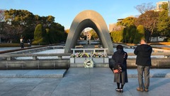 広島平和記念公園の記念碑の前で祈りをささげる人たち