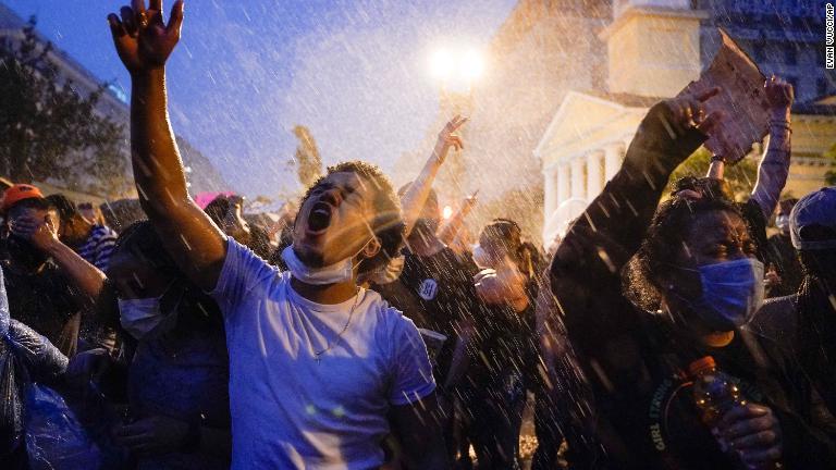雨の中、デモを行う人々＝６月４日、ワシントン/Evan Vucci/AP