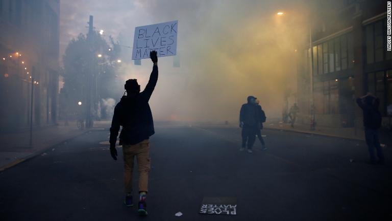 「黒人の命も大切だ」というスローガンを掲げる人物＝６月１日、ワシントン州シアトル/Lindsey Wasson/Reuters