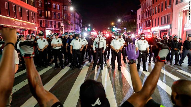 警官隊の前で片膝をつく人々＝６月４日、ニューヨーク市ブルックリン/Frank Franklin II/AP