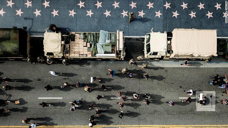 州兵の横を行進するデモ隊＝６月２日、カリフォルニア州ロサンゼルス/Ringo H.W. Chiu/AP