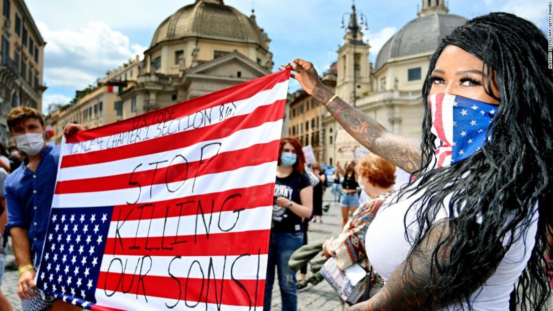 米国旗を逆さまに掲げるデモ隊＝ローマ/ALBERTO PIZZOLI/AFP/Getty Images