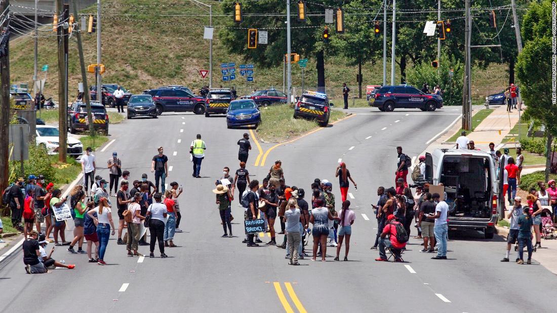 男性が死亡した駐車場の近くでデモを行う人々＝１３日/Steve Schaefer/Atlanta Journal-Constitution/AP
