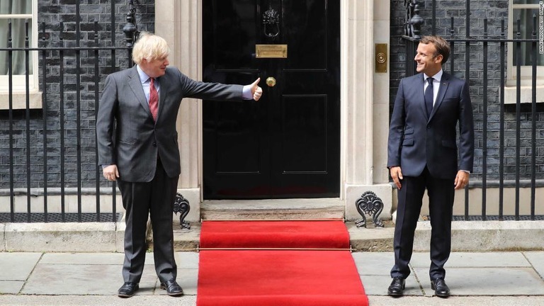 マクロン仏大統領（右）に呼びかけるジョンソン英首相＝１８日、英ロンドン/Dan Kitwood/Getty Images