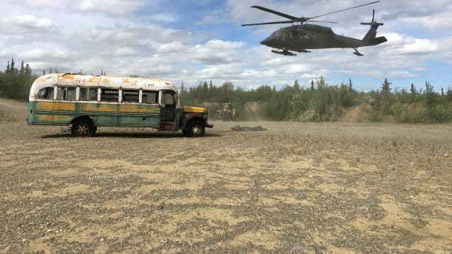 朽ちたバスの近くでホバリングする州兵のヘリ「ＵＨ－６０ブラックホーク」リ/Alaska Department of Natural Resources/Reuters
