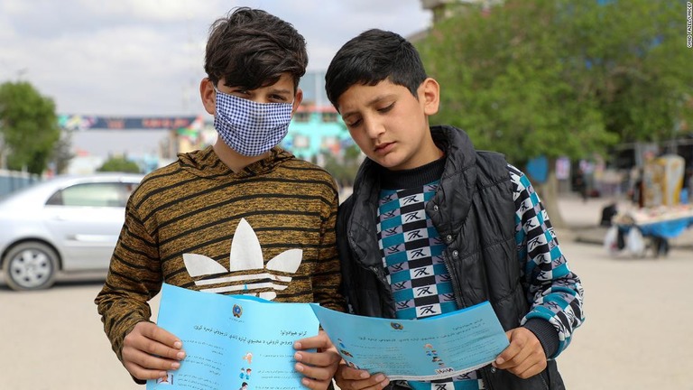 ユニセフの資料を見る子どもたち＝４月１５日、アフガニスタン/Omid Fazel/UNICEF