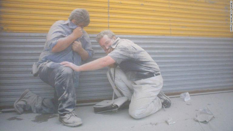 建物が倒壊し、ほこりにまみれた男性２人/Mario Tama/Getty Images