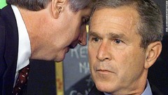 カード首席補佐官がブッシュ大統領に「米国が攻撃を受けている」と報告するところ。ブッシュ大統領は当時、フロリダ州の小学校を訪問していた