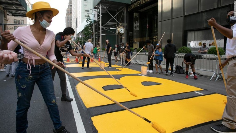トランプタワーの前で文字を描く参加者ら ９日 米ニューヨーク市