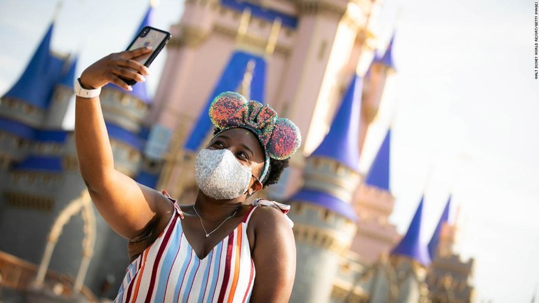 米フロリダ州のディズニーワールドで、マスクをして自撮りする来場者/Walt Disney World Resort/Getty Images