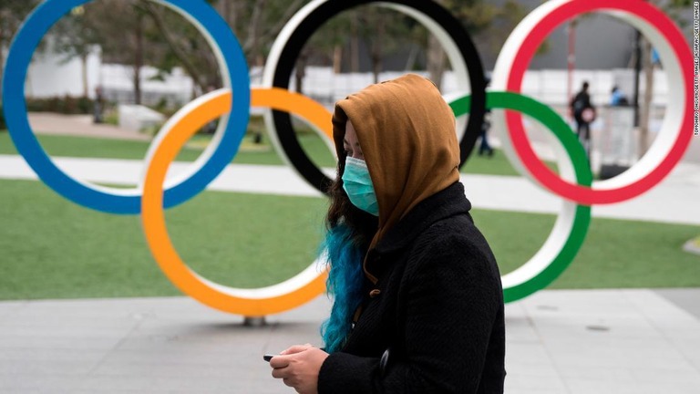 新国立競技場の五輪マークの前をマスク姿をした女性が通り過ぎる＝２０２０年２月２６日/Tomohiro Ohsumi/Getty Images AsiaPac/Getty Images
