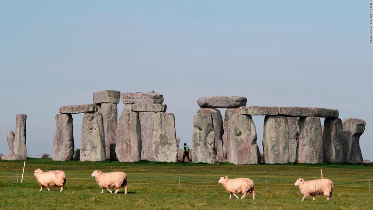 歩く羊の向こうにそびえ立つ古代の巨石遺跡「ストーンヘンジ」/Adrian Dennis/AFP/Getty Images