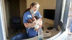破損した病院で赤ちゃんの世話をする看護師