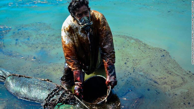 近くのブルーベイ海洋公園で油の回収作業に従事する男性/Jean Aurelio Prudence/L'Express Maurice/AFP via Getty Images