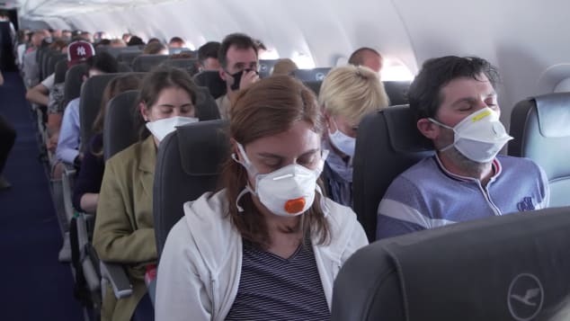 航空会社の義務付けに従い、マスクを着用して登場する旅行者ら/CNN