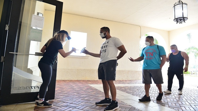 フィットネスジムの入場前にチェックを受ける人々＝７月８日、米フロリダ州/Johnny Louis/Getty Images