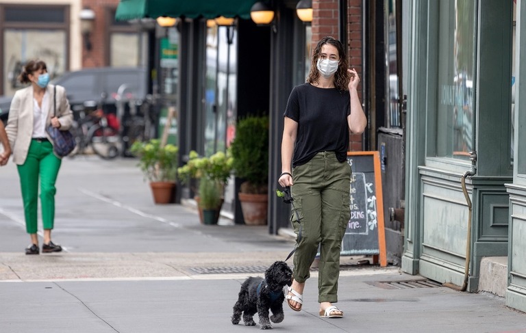 米ニューヨークの路上で犬を散歩させるマスク姿の女性/Alexi Rosenfeld/Getty Images