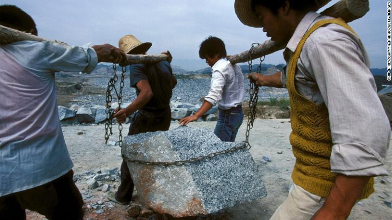 岩を運ぶ労働者＝１９９５年９月/Chip HIRES/Gamma-Rapho/Getty Images